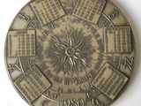 une horloge ornée d'un soleil, posée sur une surface blanche