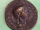 an old coin with a man ' s face on it on a green surface