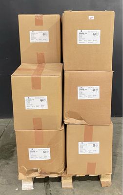 des cartons empilés sur une palette devant un mur noir