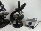 two microscopes sitting next to each other on a table
