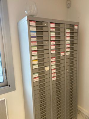 many mailboxs in a room with a window in the background