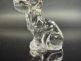 figurine en verre représentant un chien assis sur une surface noire