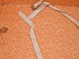 an orange and white bed spread with a pair of glasses on top of it