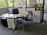 une pièce équipée d'un bureau, de chaises et d'un réfrigérateur
