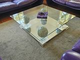 des canapés en cuir violet et une table basse en verre dans un salon