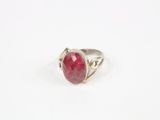 une bague en argent avec une pierre rouge au centre
