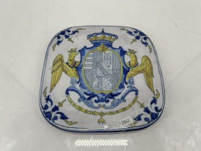 une assiette bleue et blanche sur laquelle est représenté un blason