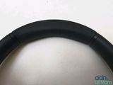 the steering wheel of a car with a black leather rim