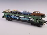 un petit train avec des wagons posés dessus, posé sur une surface blanche