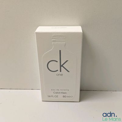 un gros plan sur un flacon de parfum posé sur une table