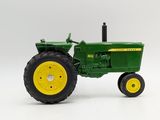 green toy tractor with yellow wheels on a white background