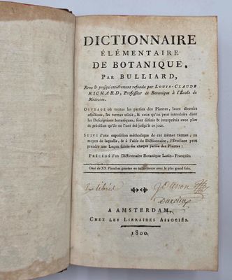 un livre ouvert avec une écriture dessus, posé sur une table