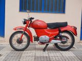 a red motorcycle parked on the sidewalk in front of a building