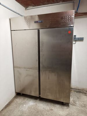 two stainless steel refrigerators in a room with white walls