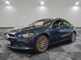 a blue mercedes cla parked in a garage with a checkered floor