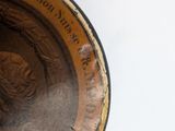 a close up of a bronze plate with a woman on it