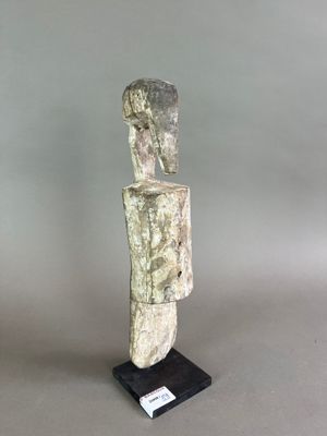 statue d'un homme dont la tête repose sur un socle, sur fond gris