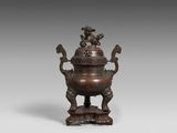 un ancien brûle-parfum en bronze surmonté d'un oiseau