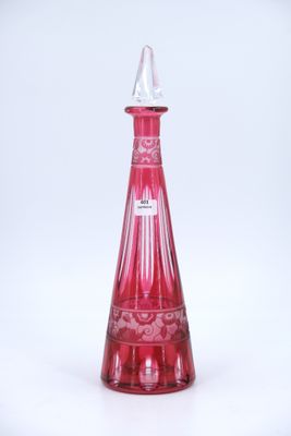 a red glass bottle with a white top on a white surface