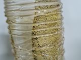 a close up of a clear glass vase with a gold decoration