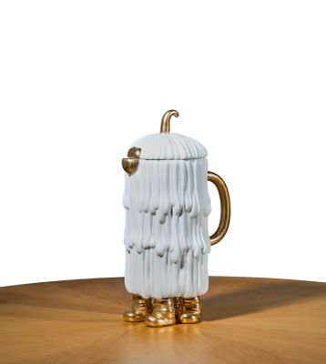une tasse en céramique blanche avec une anse dorée posée sur une table en bois