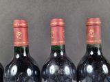 several bottles of wine are lined up on a shelf