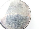 a close up of a silver plate on a white surface