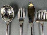 four spoons and a fork on a table