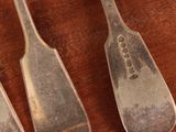 three spoons that are sitting on a wooden table
