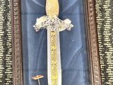 a picture of a framed picture of a sword with a crown on it