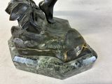 a statue of a dog on a rock with a bird on it