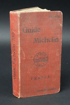 an old red book sitting on top of a black table