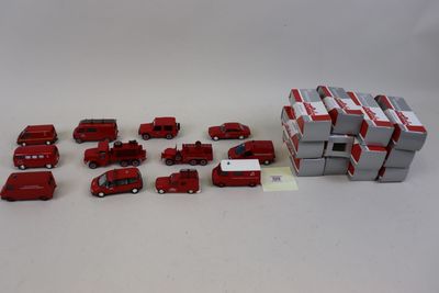 plein de petits camions rouges et blancs et une boîte remplie de boîtes