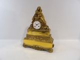 une horloge en or posée sur une table blanche