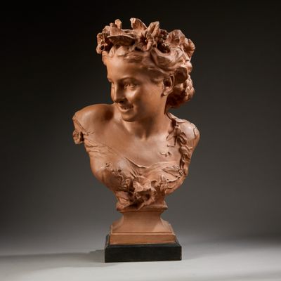 une sculpture représentant une tête de femme posée sur un socle en bois