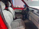 the interior of a red car with grey seats and a steering wheel
