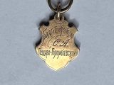 an image of a small gold medal with the name of a police officer on it
