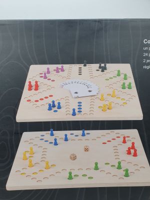 two wooden board game pieces with colorful pieces on them in a box