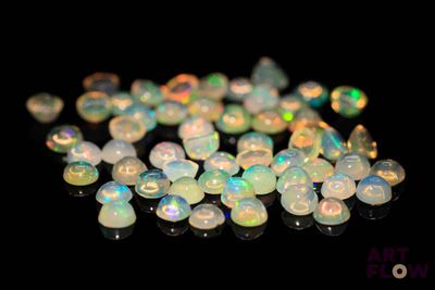 some white oplites are scattered on a black surface