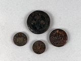 trois vieilles pièces de monnaie posées les unes à côté des autres sur une surface blanche