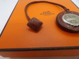 an orange box with a watch inside of it on a white surface