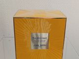 the box of the perfume is sitting on a glass table