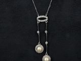 a woman wearing a necklace and earrings with pearls on it