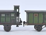 deux petits trains miniatures posés côte à côte sur une surface blanche