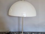 une lampe de table blanche posée sur un plan de travail en marbre