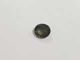 a green tourmaline gemstone on a white surface