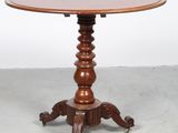 une table en bois avec un plateau rond et un piètement en bois