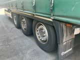 a close up of a green semi truck with a flat tire