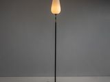 un lampadaire noir surmonté d'un abat-jour blanc