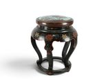 un petit tabouret noir dont l'assise est peinte sur fond blanc